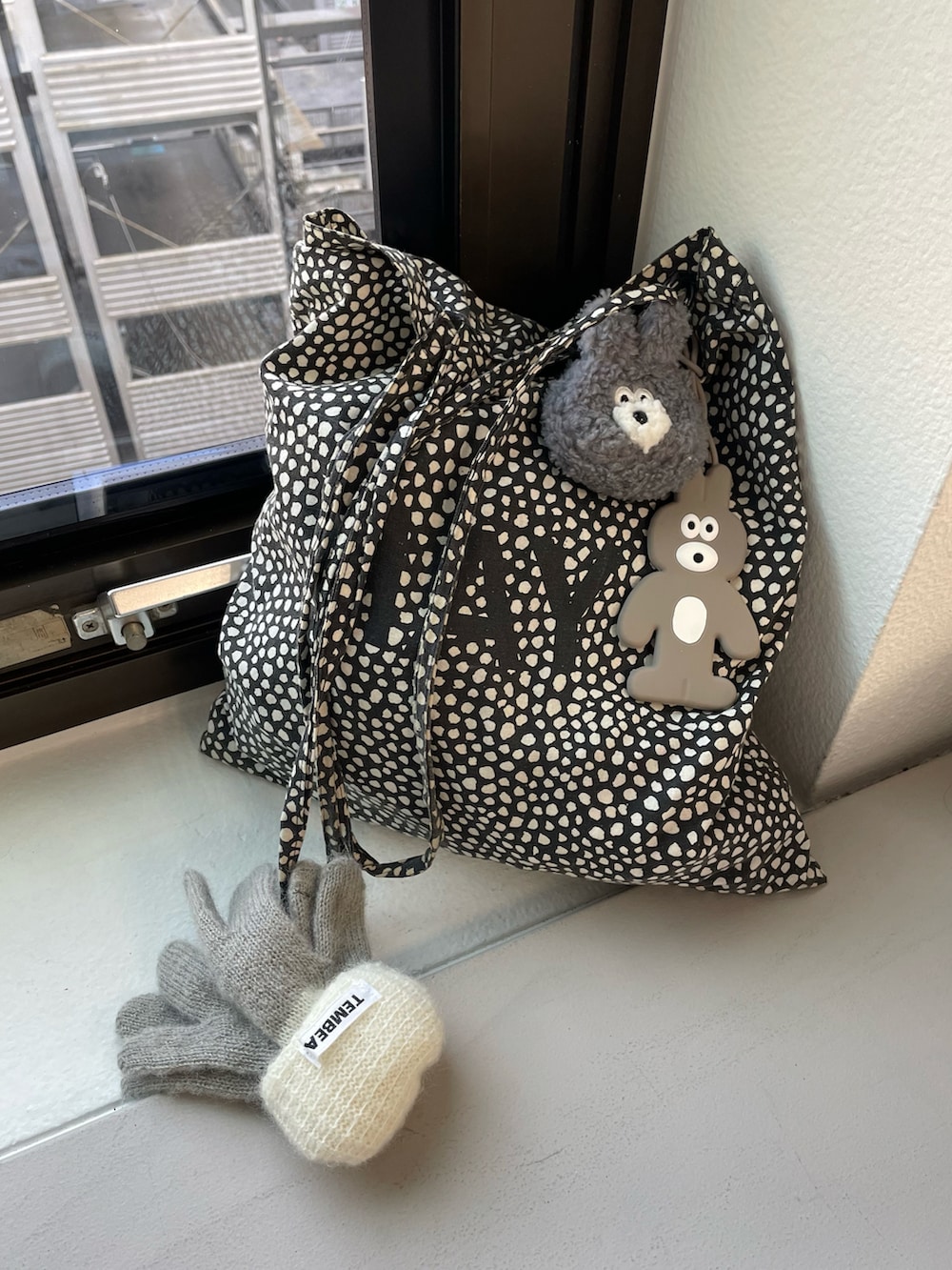 グレー系のトラベルグッズ、グレー系のヘッドフォン/イヤホンを着用したレディースの冬コーディネートの3枚目の写真