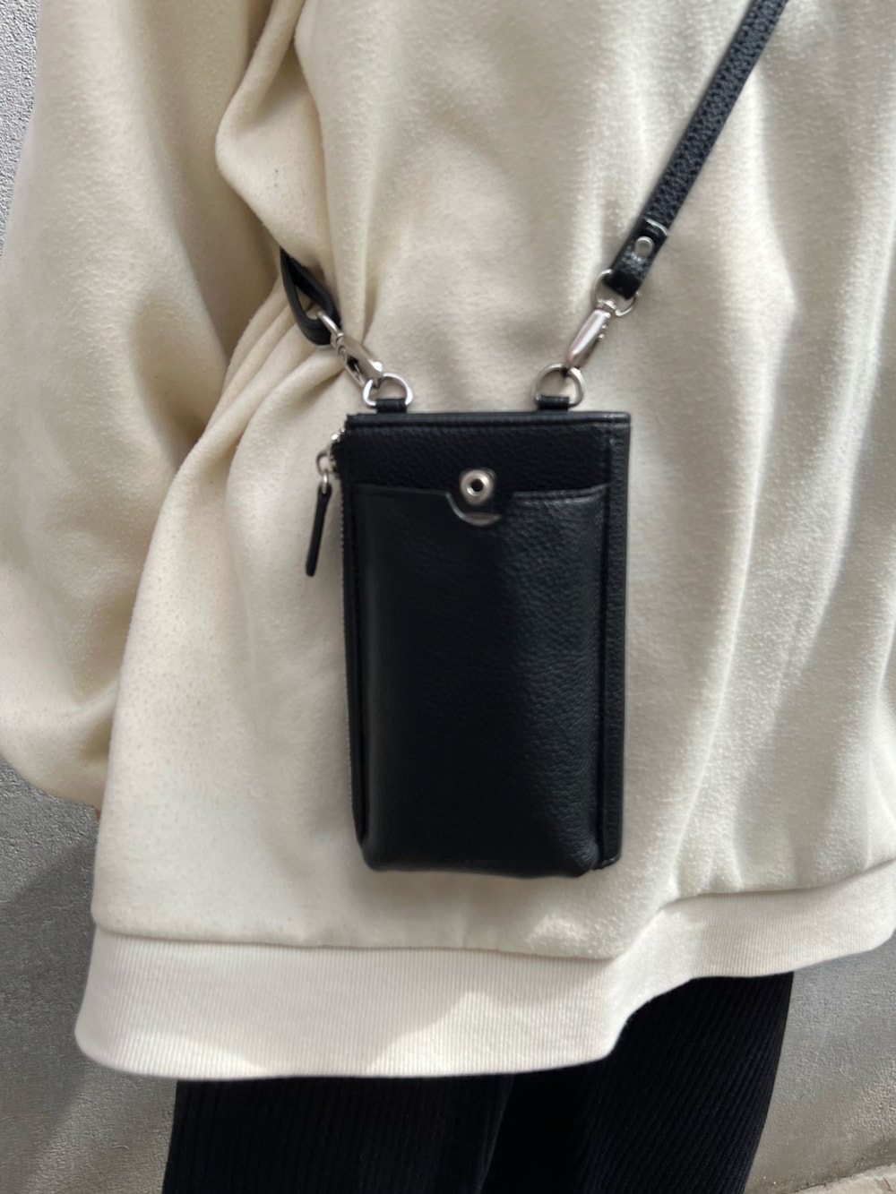 ブラック系のショルダーバッグ、ブラック系のスカート、ホワイト系のスウェットを着用したレディースの春コーディネートの3枚目の写真