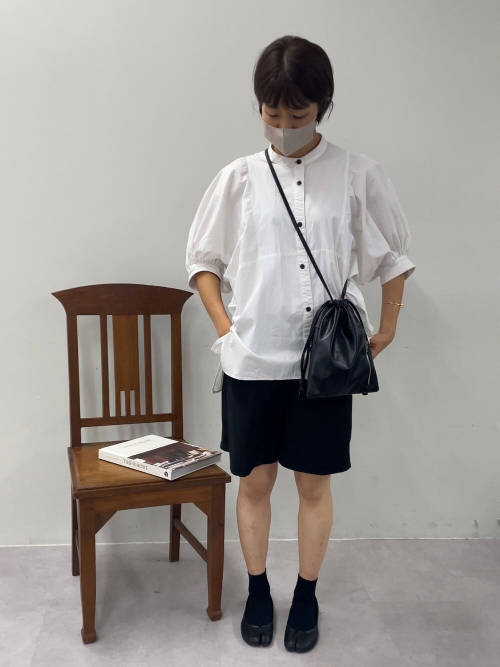 ブラック系のショルダーバッグ、ホワイト系のシャツ/ブラウス、ブラック系のパンツを着用したレディースの秋コーディネートの3枚目の写真