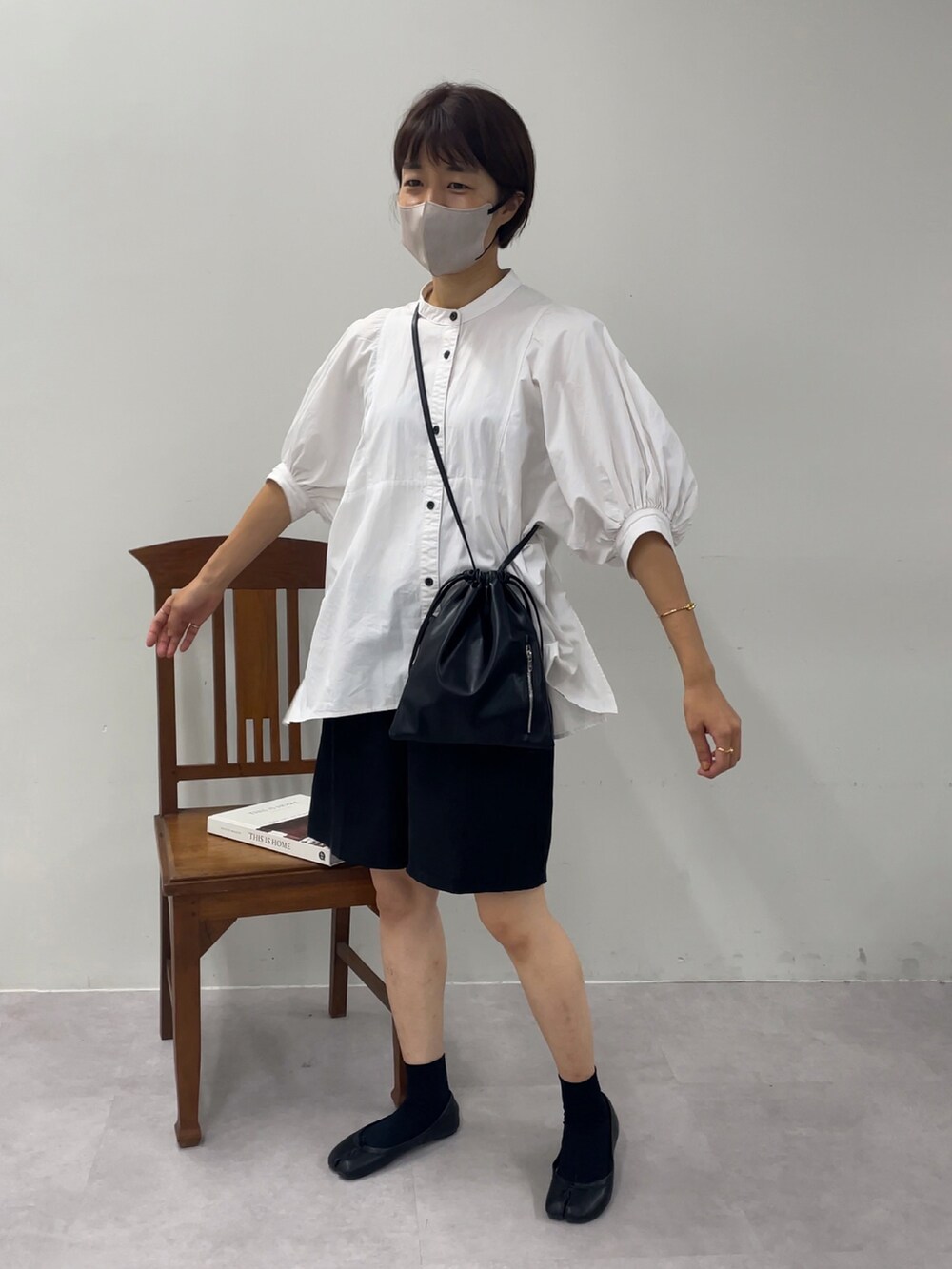 ブラック系のショルダーバッグ、ホワイト系のシャツ/ブラウス、ブラック系のパンツを着用したレディースの秋コーディネートの2枚目の写真