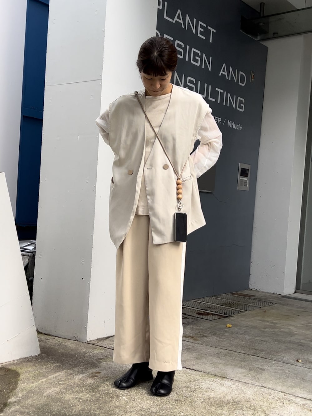 ホワイト系のベスト、ベージュ系のその他パンツ、ブラック系のブーツを着用したレディースの秋コーディネートの2枚目の写真