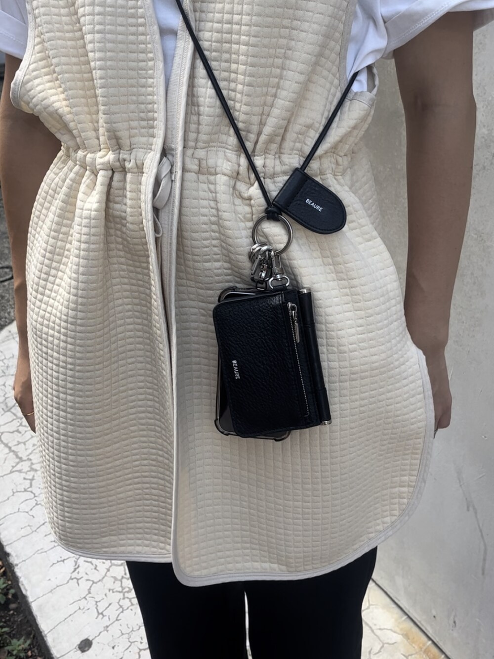 ベージュ系のベスト、ホワイト系のTシャツ/カットソー、ブラック系のその他パンツを着用したレディースの夏コーディネートの3枚目の写真