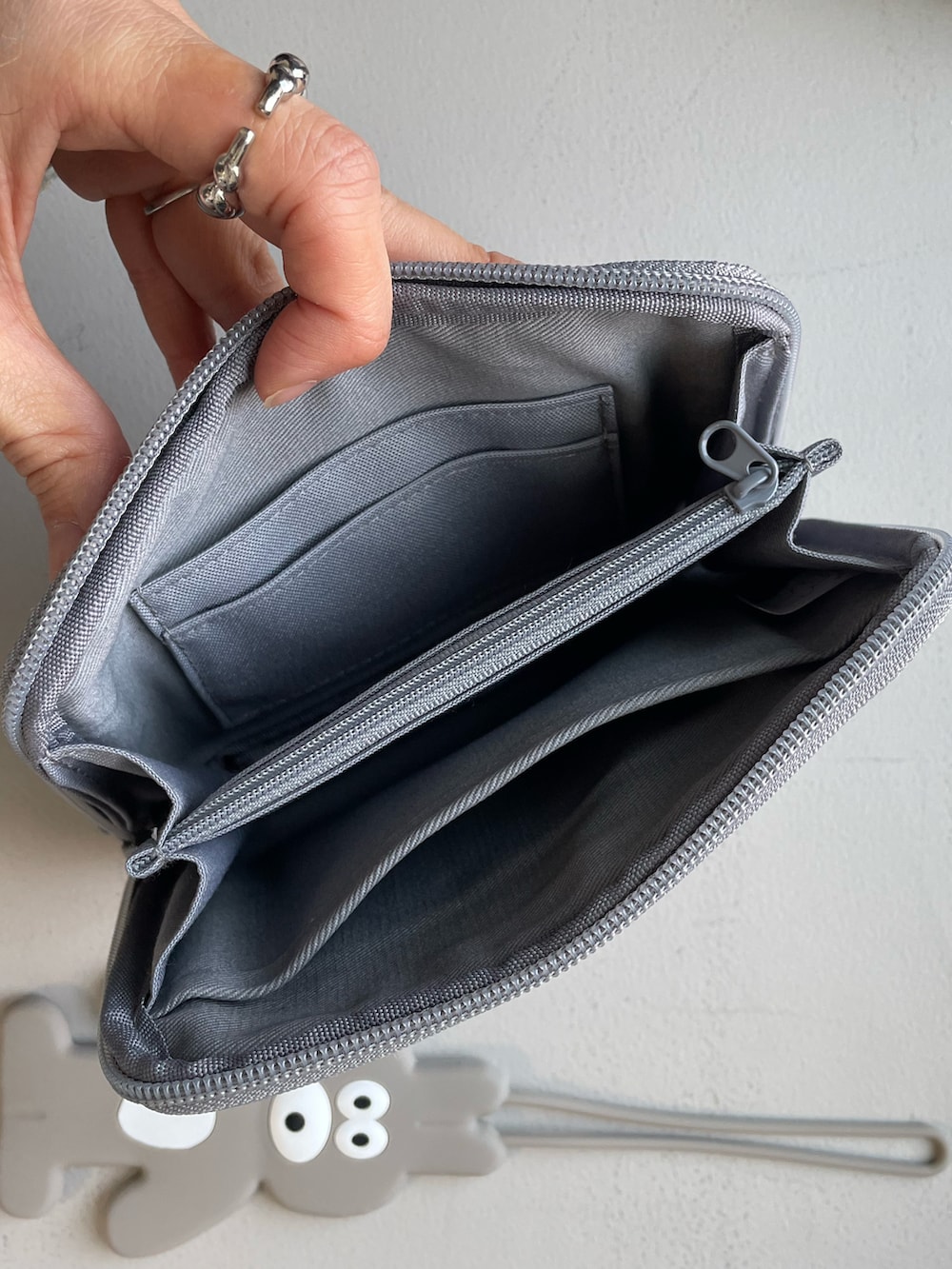 グレー系のトラベルグッズ、グレー系のヘッドフォン/イヤホンを着用したレディースの冬コーディネートの2枚目の写真