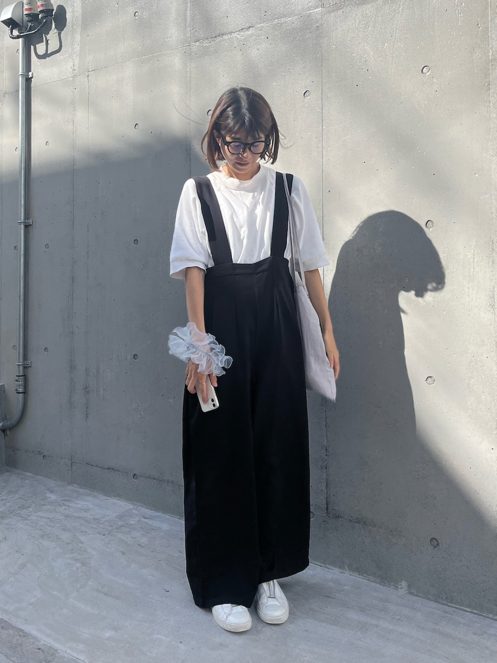 グレー系のトートバッグ、ブラック系のサロペット/オーバーオールを着用したレディースの夏コーディネートの2枚目の写真