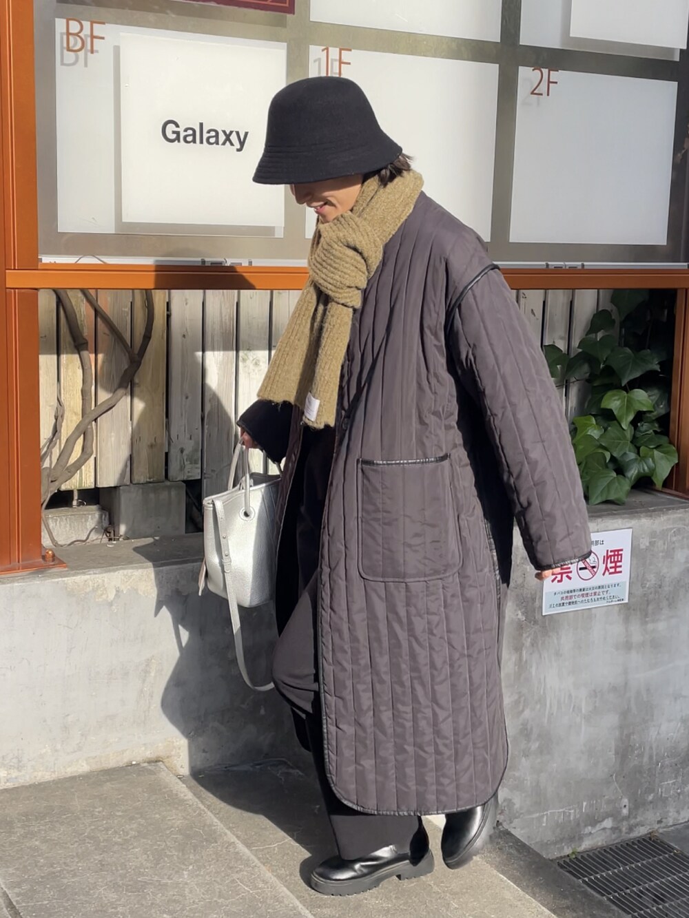 シルバー系のトートバッグ、ブラック系のその他パンツ、ブラック系のダウンジャケット/コートを着用したレディースの冬コーディネートの2枚目の写真