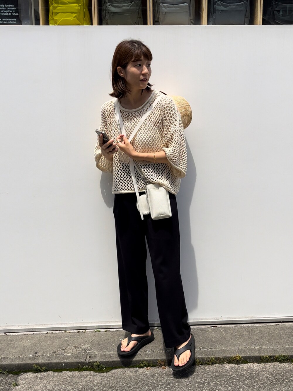 ホワイト系のショルダーバッグ、ホワイト系のニット/セーター、ブラック系のサンダルを着用したレディースの夏コーディネートの2枚目の写真