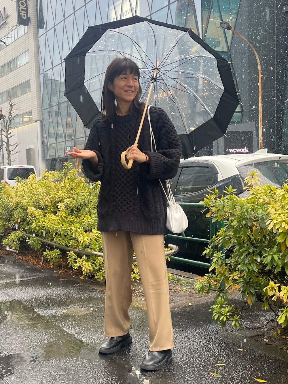 ホワイト系のショルダーバッグ、ブラック系のニット/セーター、ベージュ系のその他パンツを着用したレディースの冬コーディネートの2枚目の写真