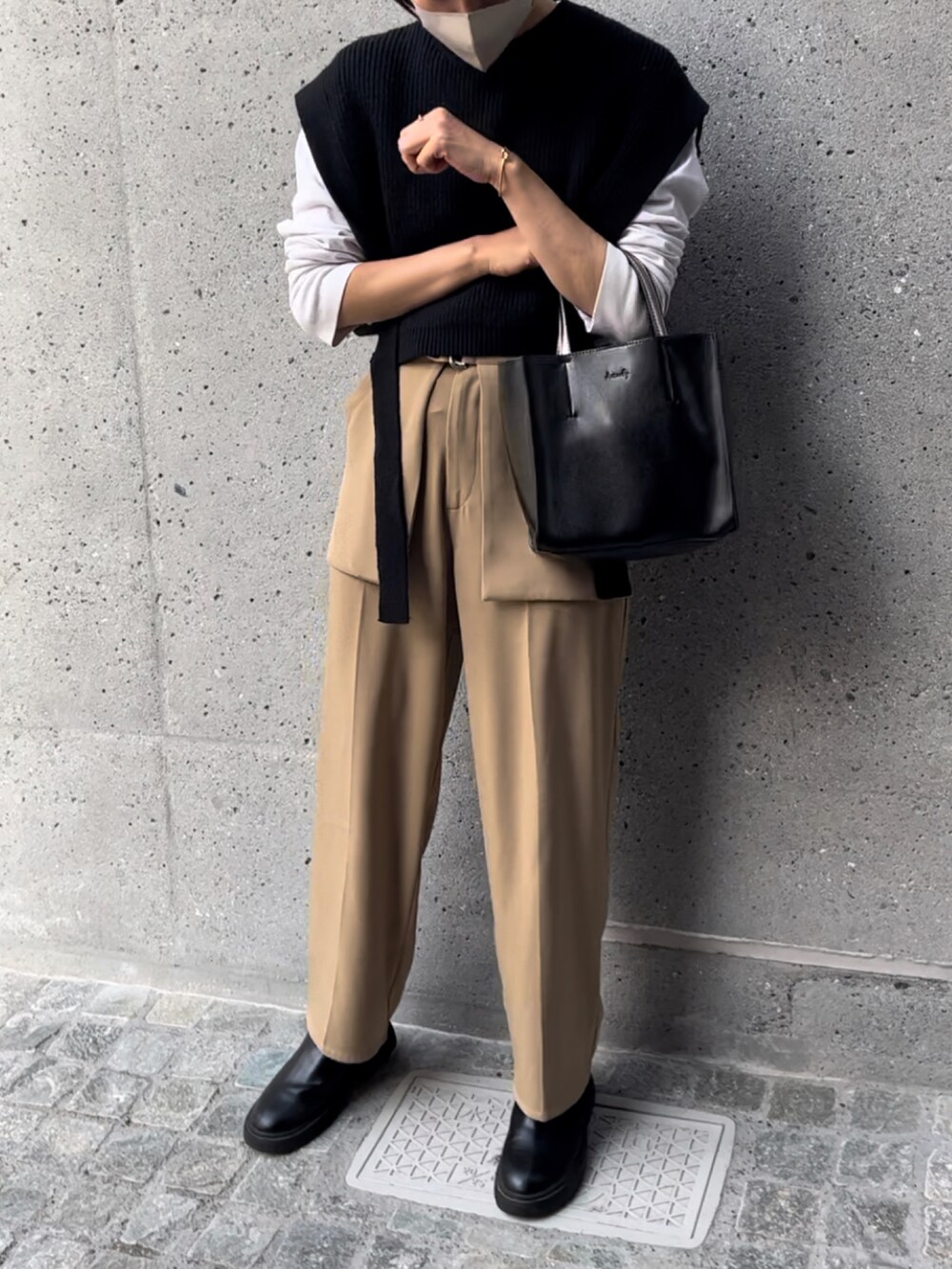 ブラック系のトートバッグ、ブラック系のベスト、ベージュ系のその他パンツを着用したレディースの秋コーディネートの3枚目の写真