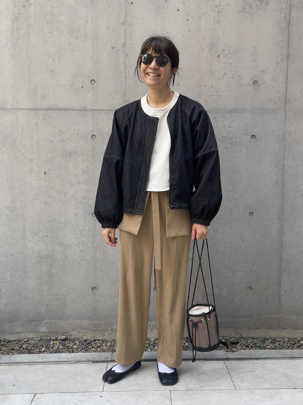 ブラック系のトートバッグ、ベージュ系のその他パンツ、ブラック系のデニムジャケットを着用したレディースの冬コーディネートの2枚目の写真