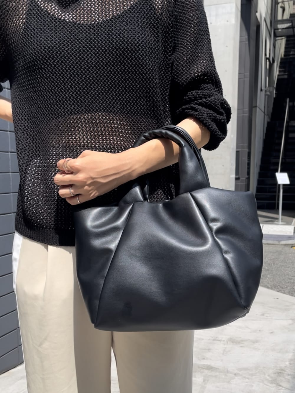 ブラック系のサンダル、ベージュ系のその他パンツ、ブラック系のニット/セーターを着用したレディースの夏コーディネートの2枚目の写真