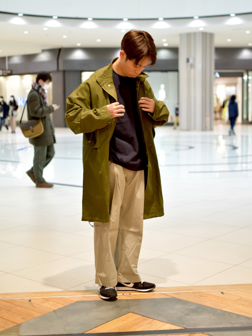 グリーン系のミリタリージャケットを着用したメンズの春コーディネートの2枚目の写真