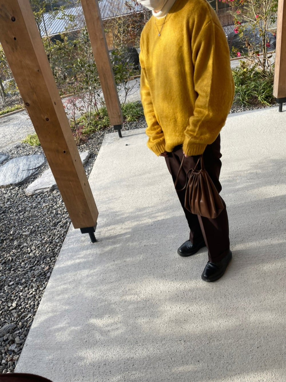 ブラック系のドレスシューズ、ブラウン系のショルダーバッグ、ブラウン系のスラックスを着用したメンズの冬コーディネートの2枚目の写真