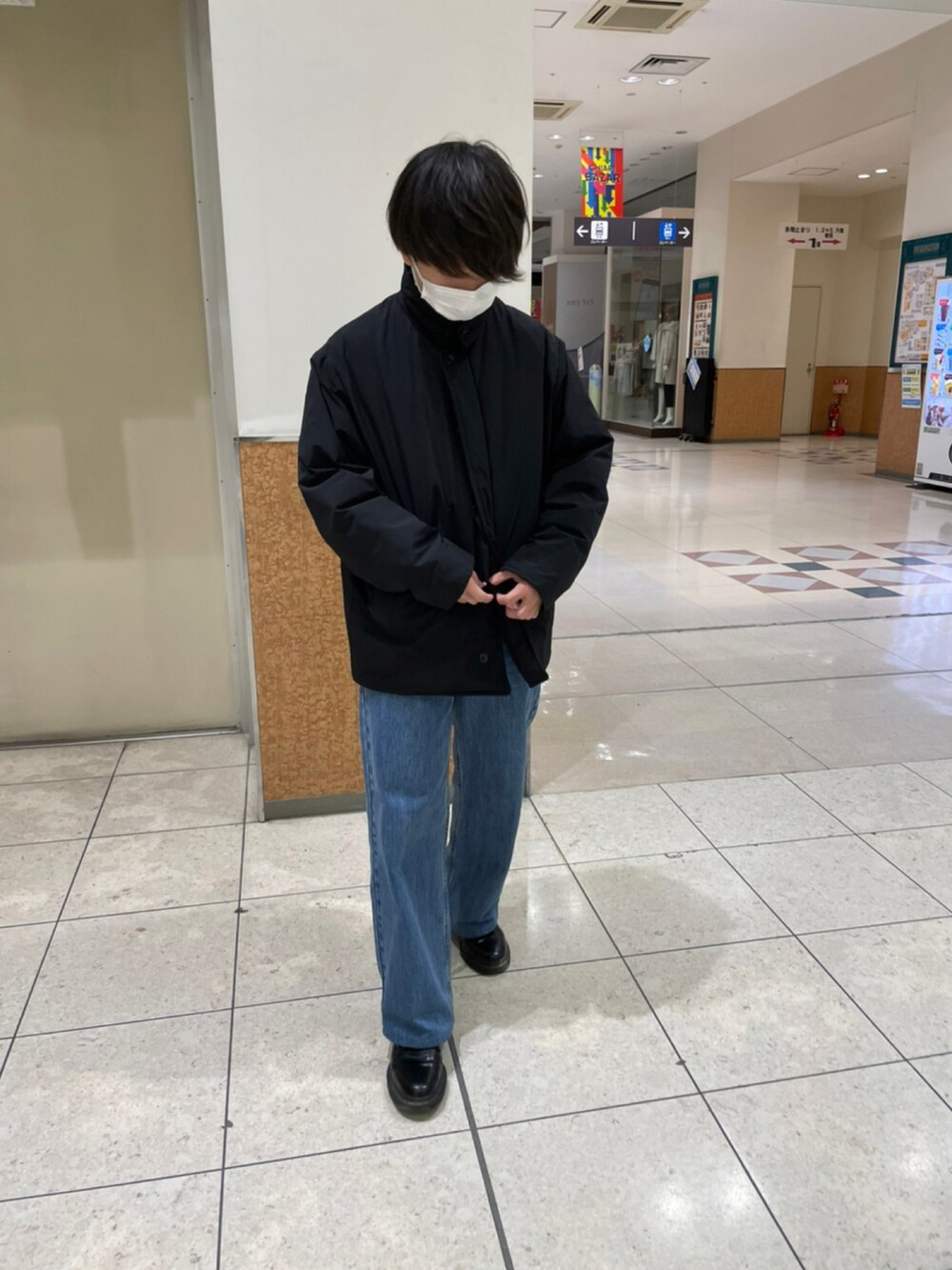 ブラック系のダウンジャケット/コート、ブラック系のドレスシューズ、ブルー系のデニムパンツを着用したメンズの冬コーディネートの2枚目の写真