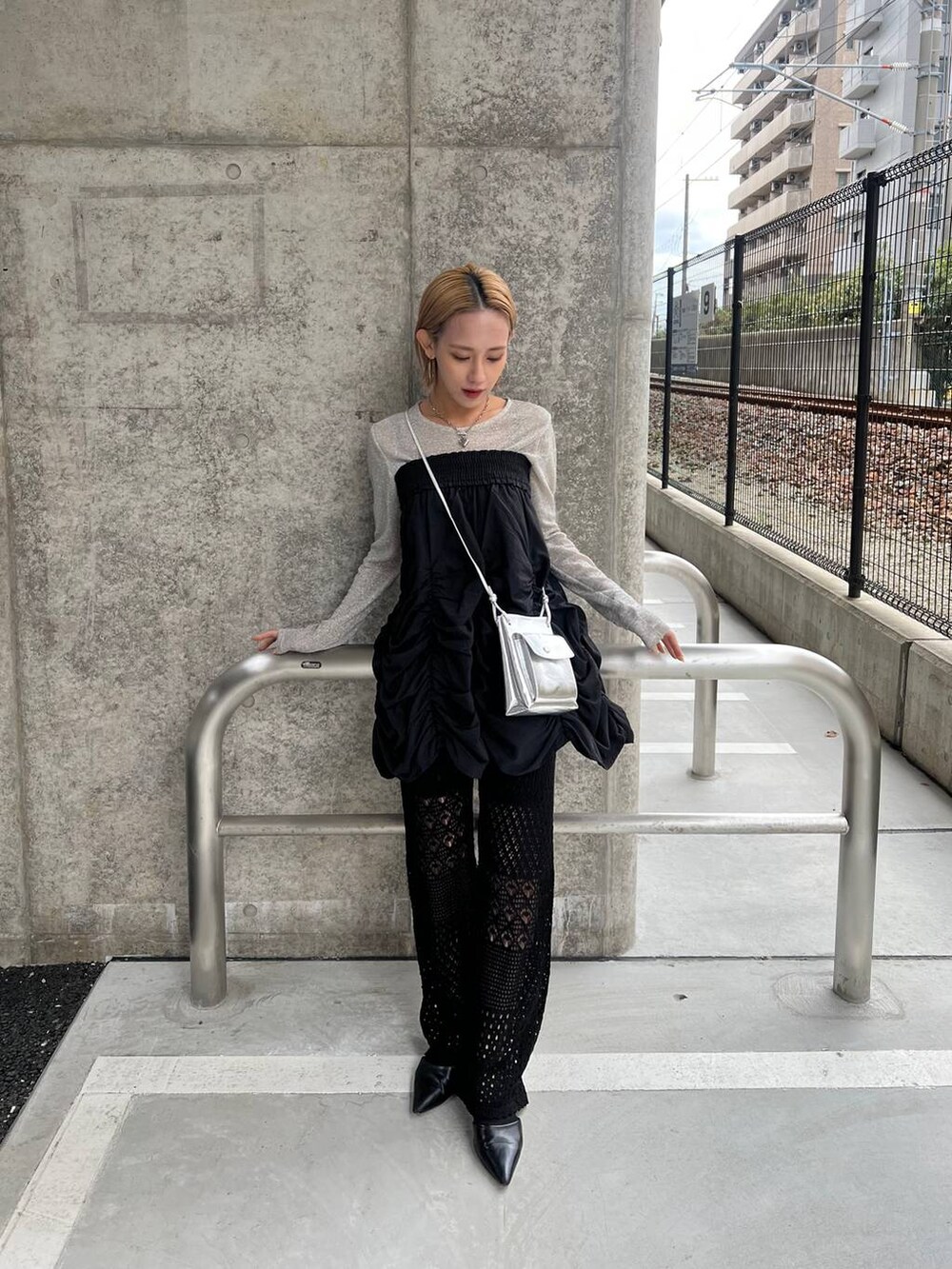 ブラック系のスカート、シルバー系のショルダーバッグ、ブラック系のパンプスを着用したレディースの春コーディネートの4枚目の写真