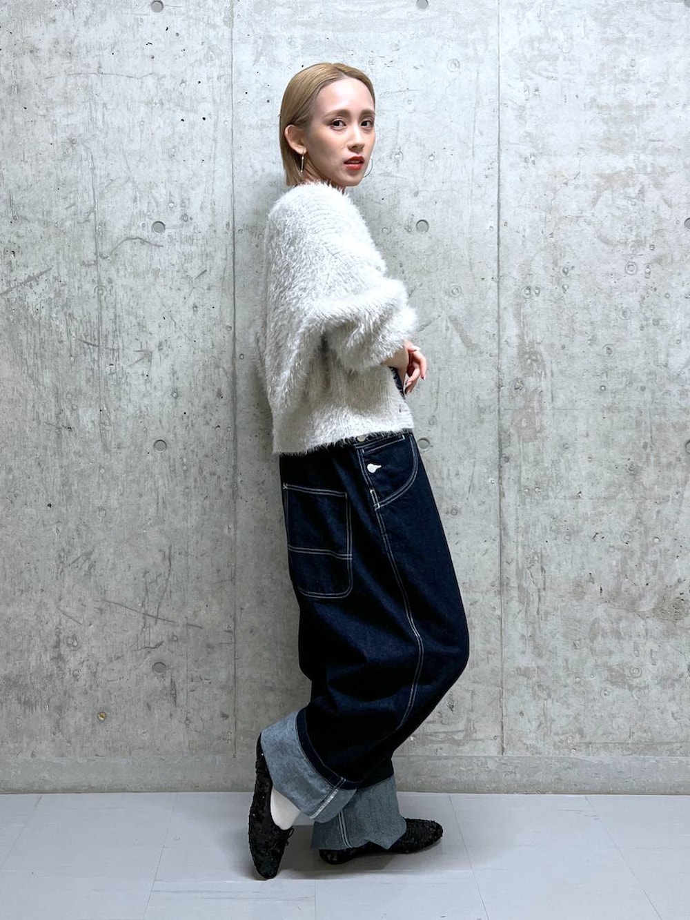 グレー系のニット/セーター、ホワイト系のTシャツ/カットソー、ブルー系のサロペット/オーバーオールを着用したレディースの冬コーディネートの2枚目の写真