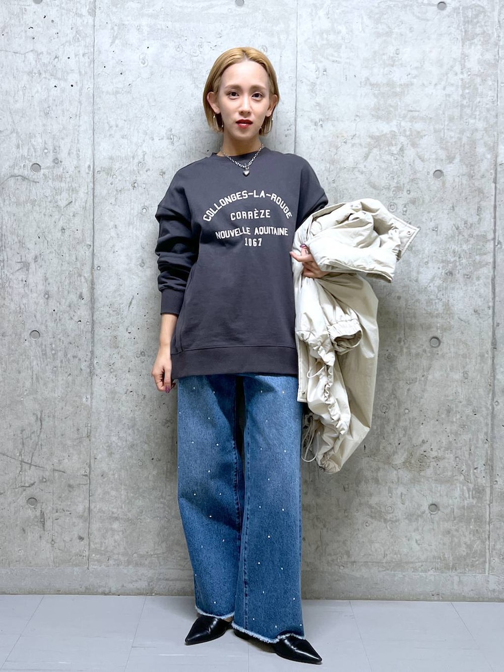 ブラック系のパンプス、ホワイト系のダウンジャケット/コート、グレー系のスウェットを着用したレディースの冬コーディネートの2枚目の写真