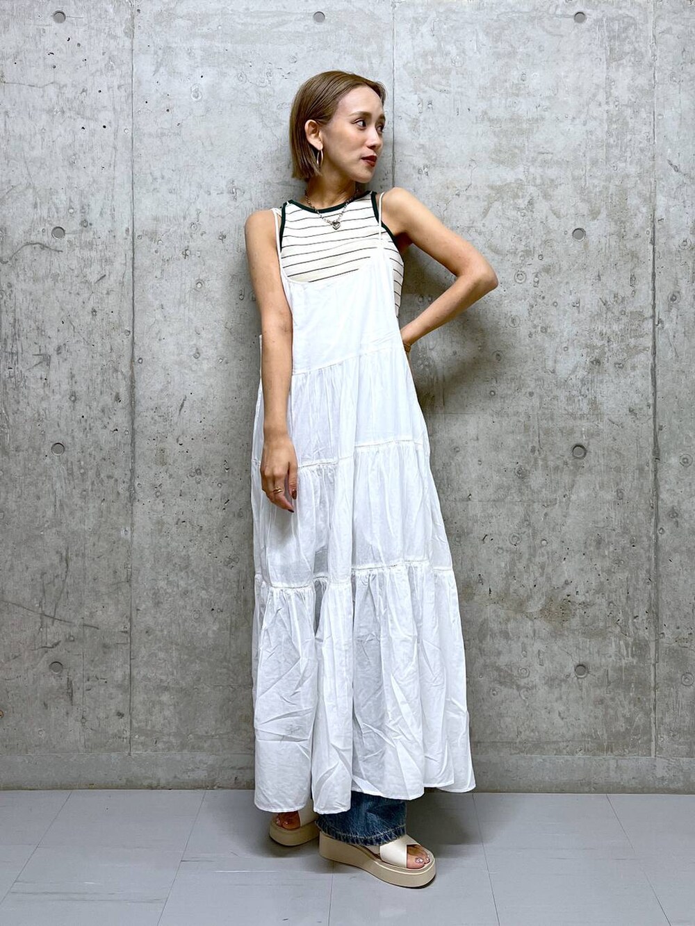 ベージュ系のタンクトップ、ホワイト系のワンピース、ホワイト系のサンダルを着用したレディースの夏コーディネートの2枚目の写真