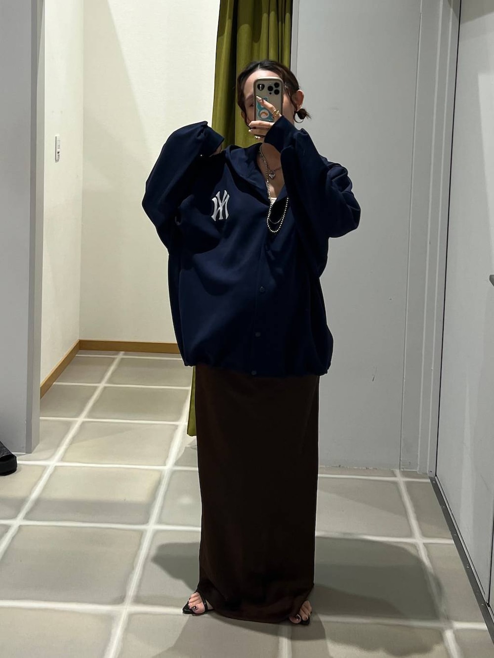 ブラック系のサンダル、ブラウン系のスカート、ブルー系のパーカーを着用したレディースの夏コーディネートの2枚目の写真