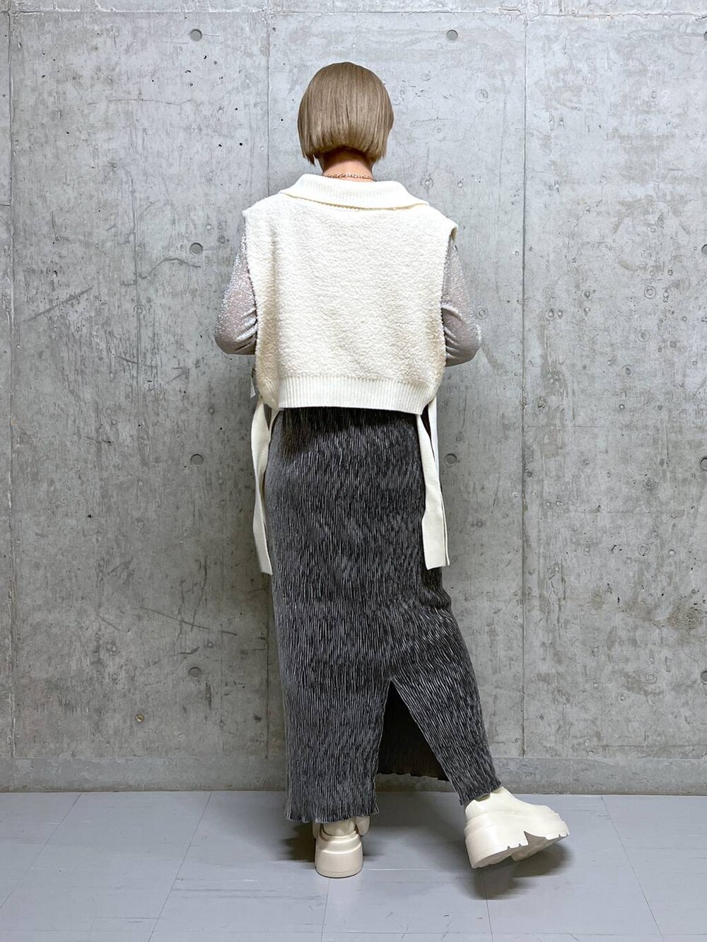 ホワイト系のブーツ、ホワイト系のTシャツ/カットソー、グレー系のスカートを着用したレディースの冬コーディネートの4枚目の写真