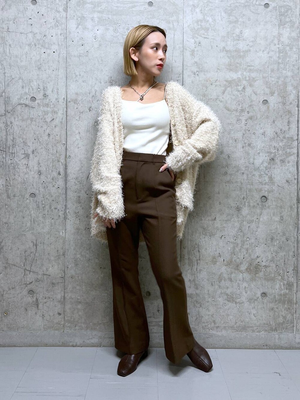 ホワイト系のタンクトップ、ブラウン系のブーツ、ホワイト系のカーディガン/ボレロを着用したレディースの秋コーディネートの2枚目の写真