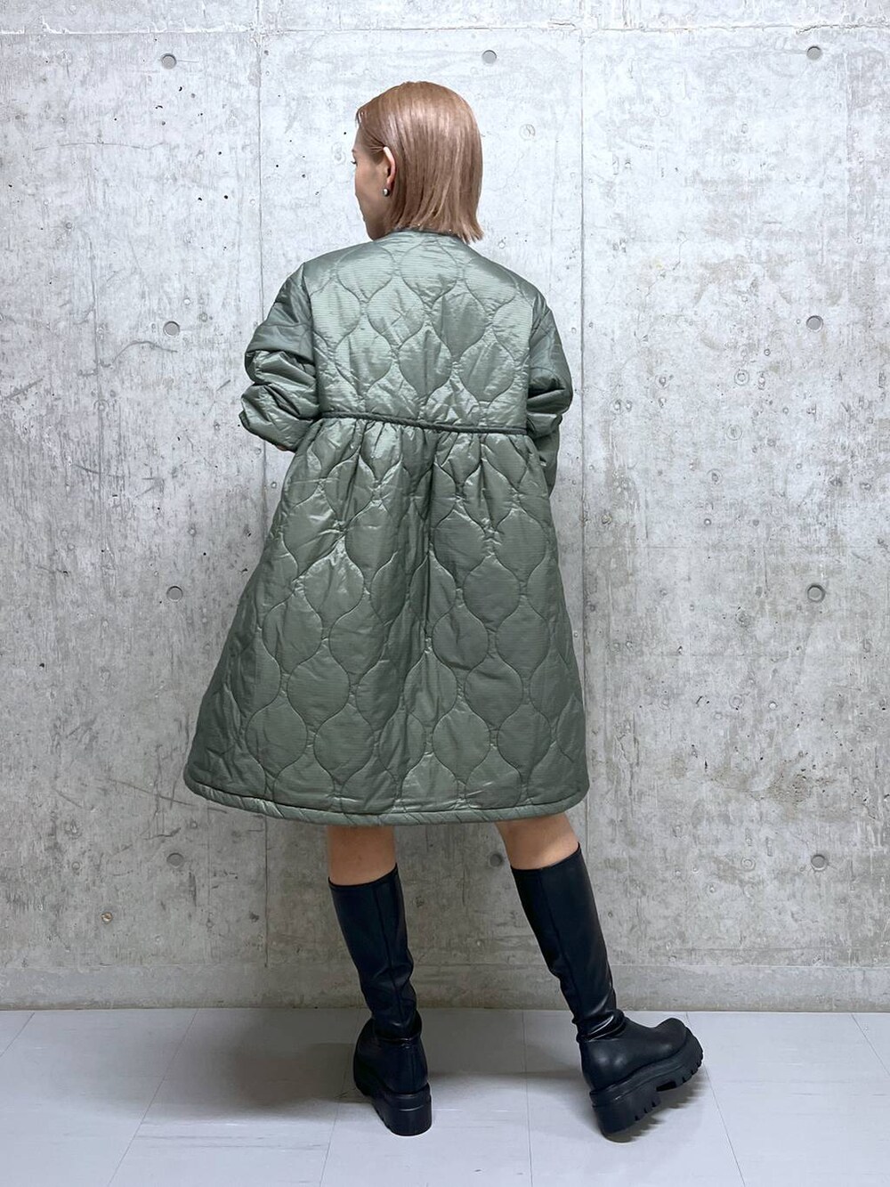 グリーン系のミリタリージャケット、ブラック系のブーツ、ブラック系のボストンバッグを着用したレディースの秋コーディネートの4枚目の写真