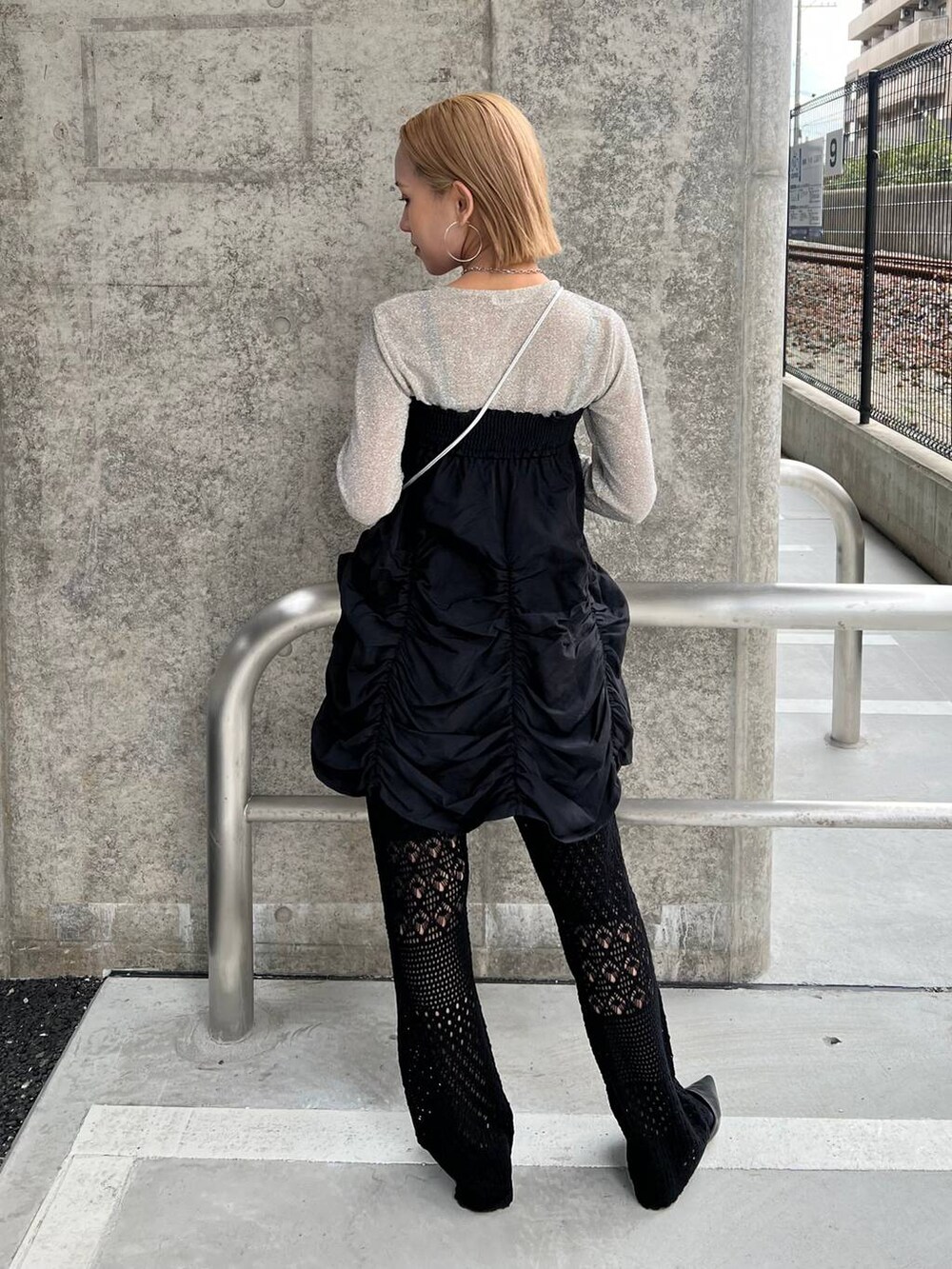 ブラック系のスカート、シルバー系のショルダーバッグ、ブラック系のパンプスを着用したレディースの春コーディネートの3枚目の写真