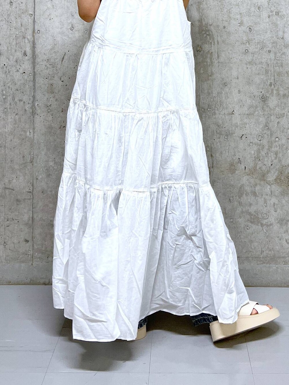 ベージュ系のタンクトップ、ホワイト系のワンピース、ホワイト系のサンダルを着用したレディースの夏コーディネートの4枚目の写真