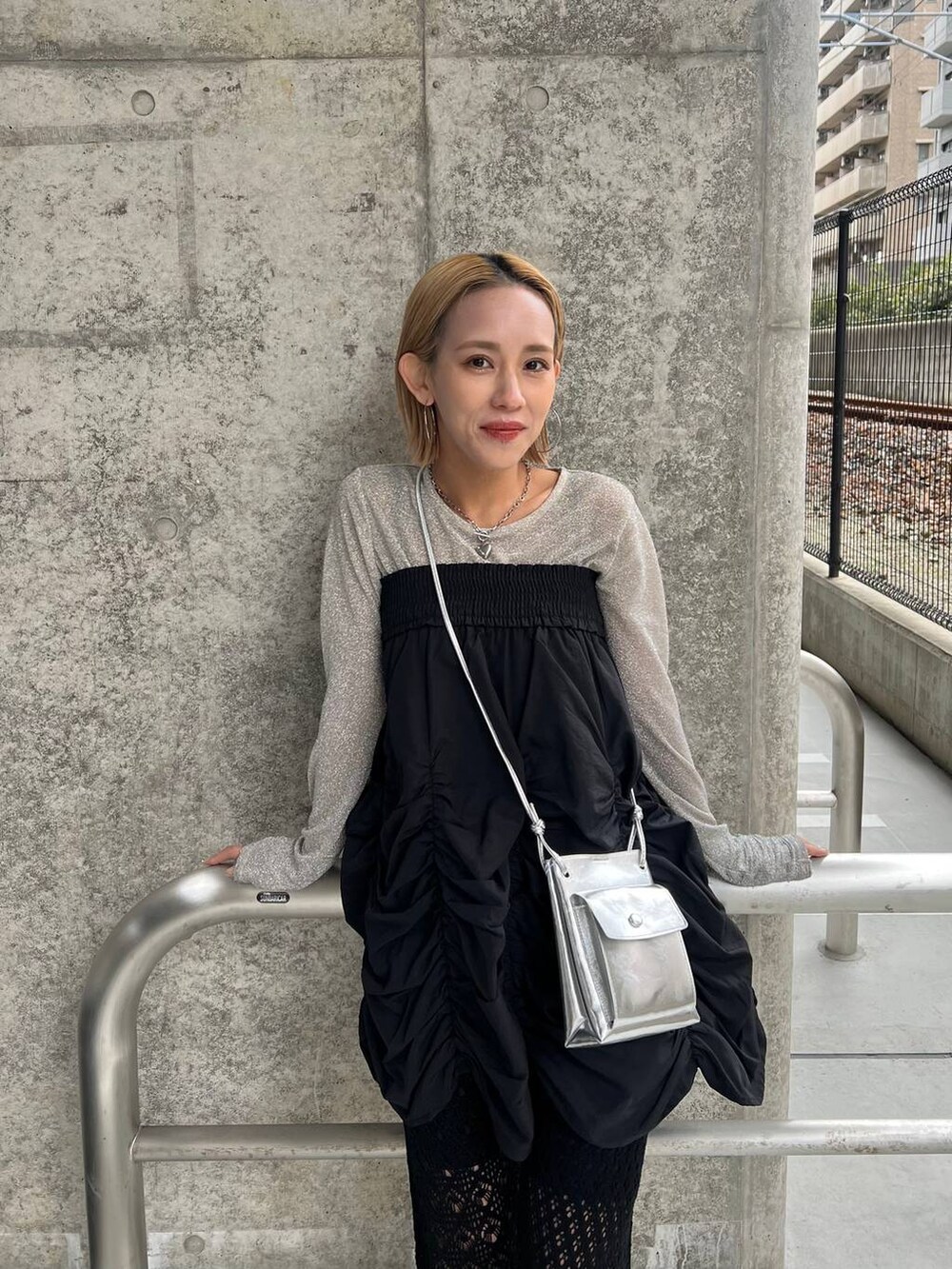 ブラック系のスカート、シルバー系のショルダーバッグ、ブラック系のパンプスを着用したレディースの春コーディネートの7枚目の写真