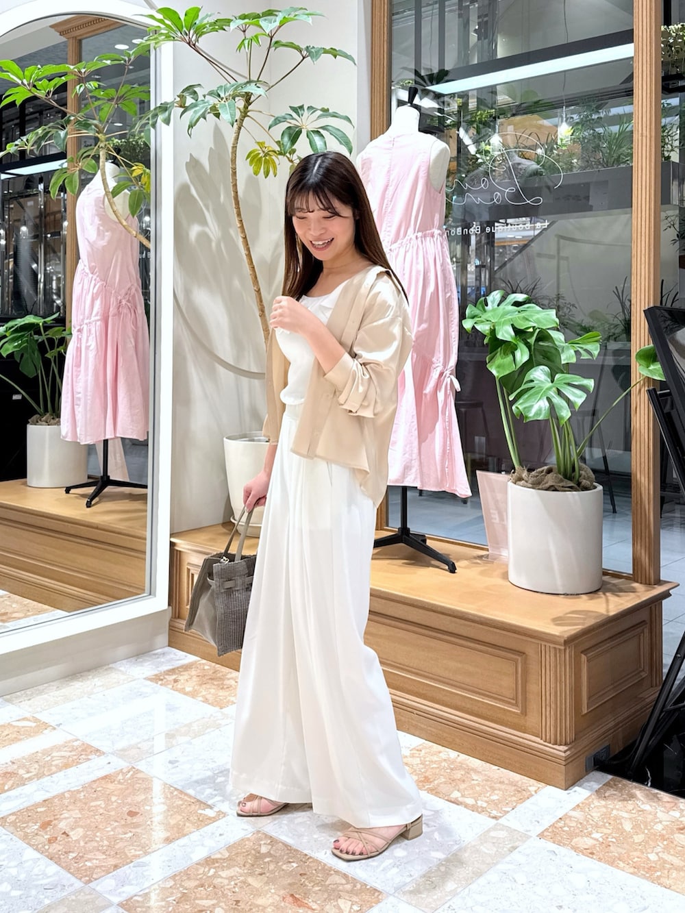 ベージュ系のシャツ/ブラウス、ホワイト系のニット/セーター、ホワイト系のスラックスを着用したレディースの夏コーディネートの2枚目の写真