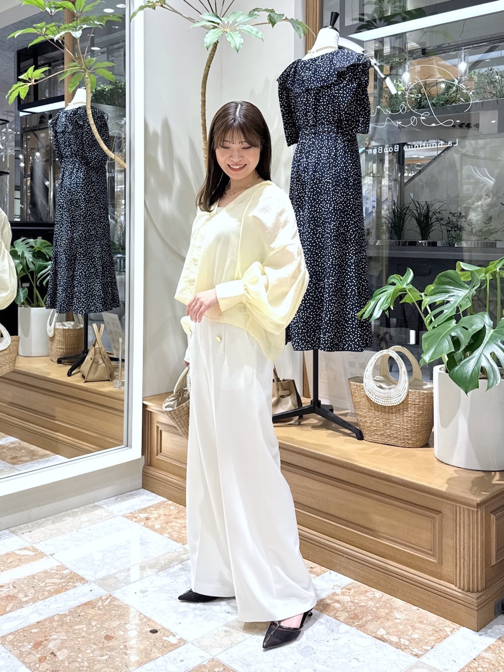 イエロー系のシャツ/ブラウス、ホワイト系のタンクトップ、ホワイト系のスラックスを着用したレディースの春コーディネートの2枚目の写真