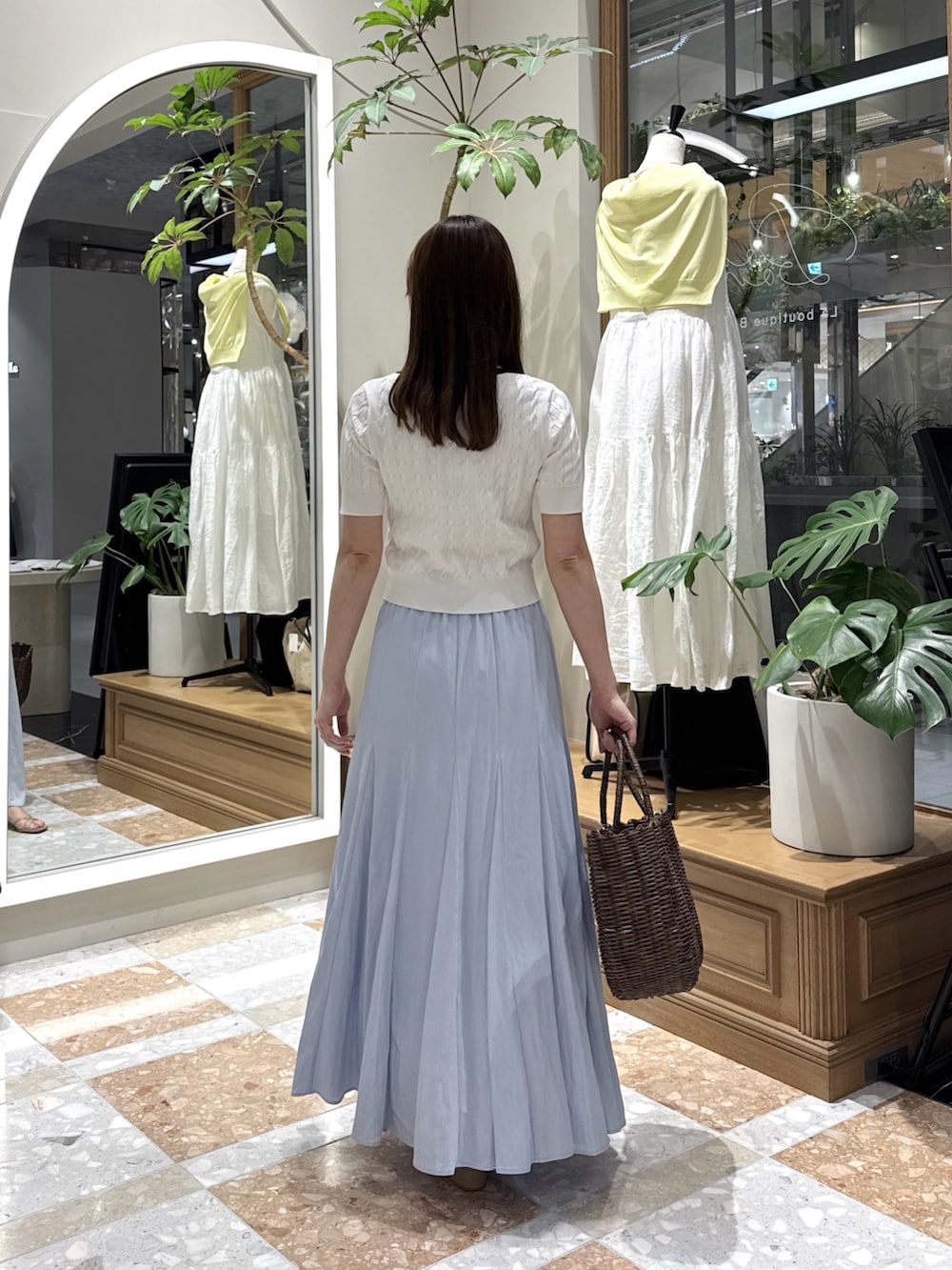 ホワイト系のニット/セーター、ブルー系のスカート、ブラウン系のトートバッグを着用したレディースの夏コーディネートの3枚目の写真