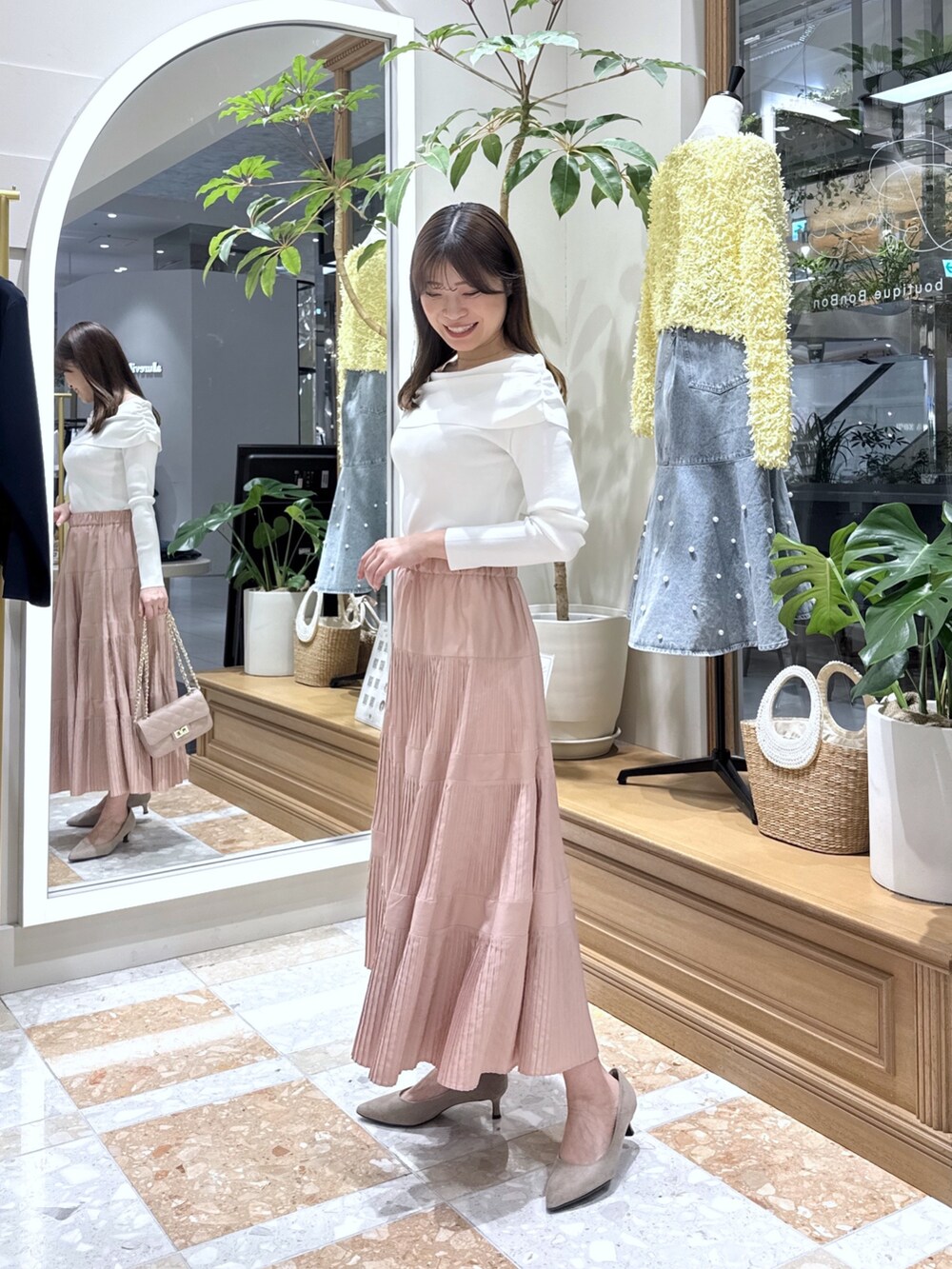 ホワイト系のニット/セーター、ピンク系のスカートを着用したレディースの冬コーディネートの2枚目の写真