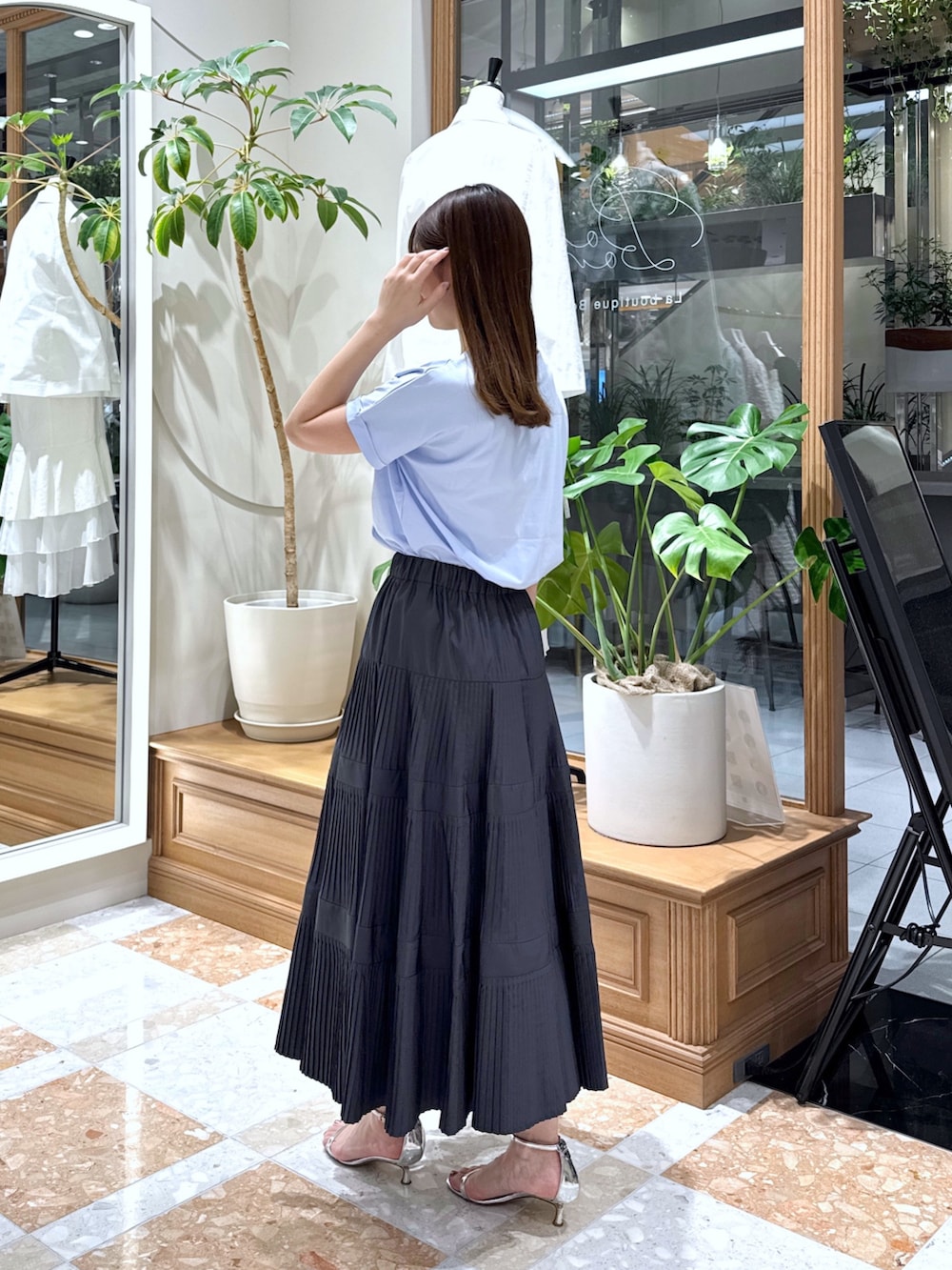 グレー系のスカート、シルバー系のハンドバッグ、ブルー系のTシャツ/カットソーを着用したレディースの春コーディネートの3枚目の写真