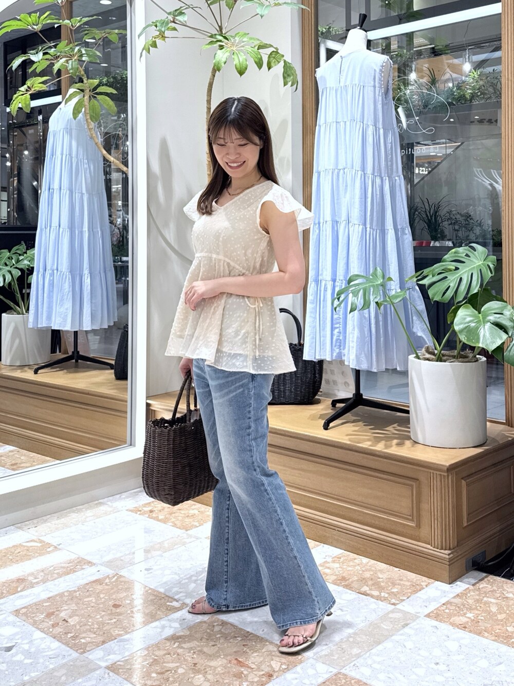 ピンク系のシャツ/ブラウス、ブルー系のデニムパンツ、ブラウン系のトートバッグを着用したレディースの夏コーディネートの2枚目の写真