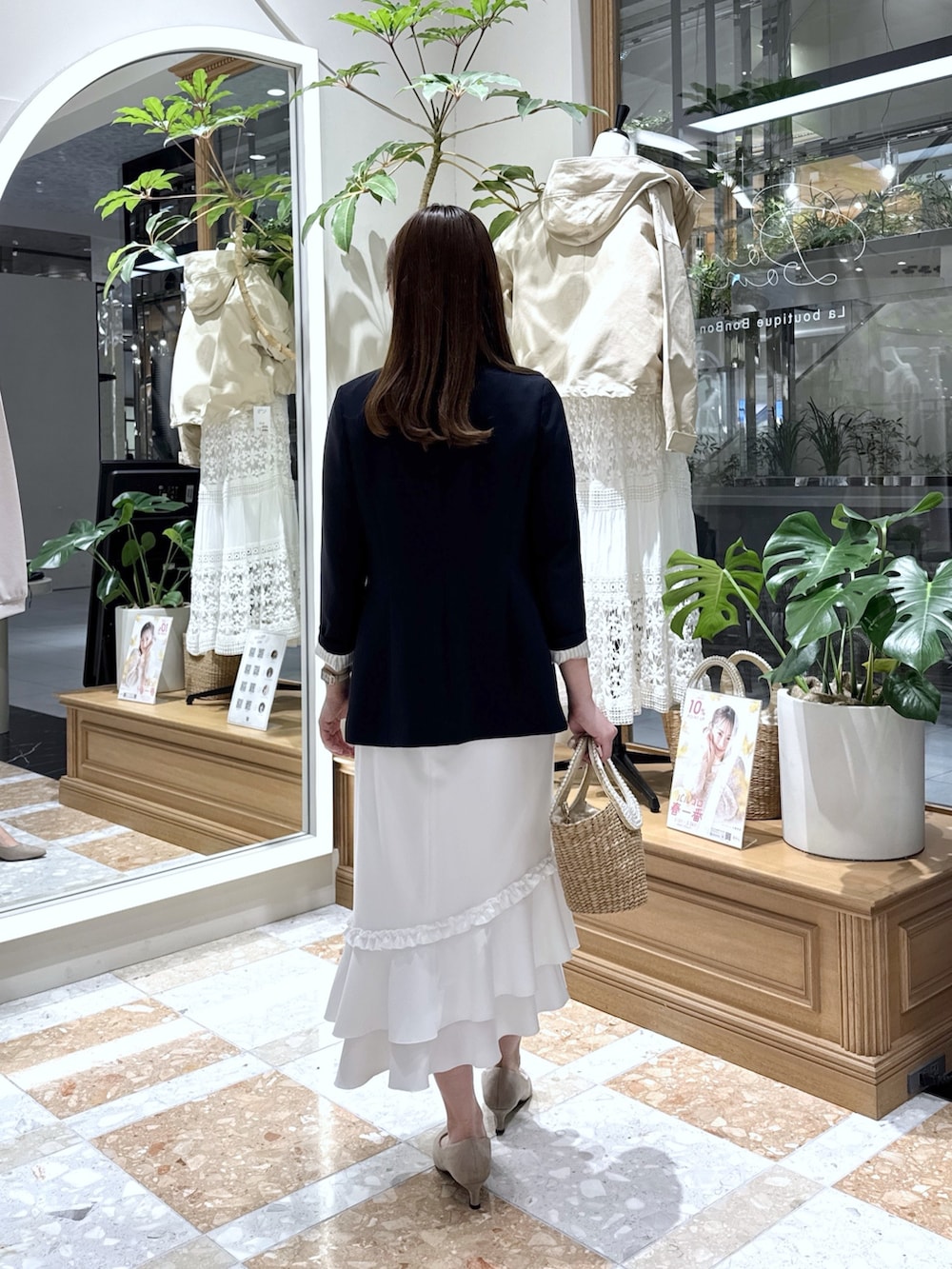 ブルー系のテーラードジャケット、ベージュ系のタンクトップ、ホワイト系のスカートを着用したレディースの冬コーディネートの3枚目の写真