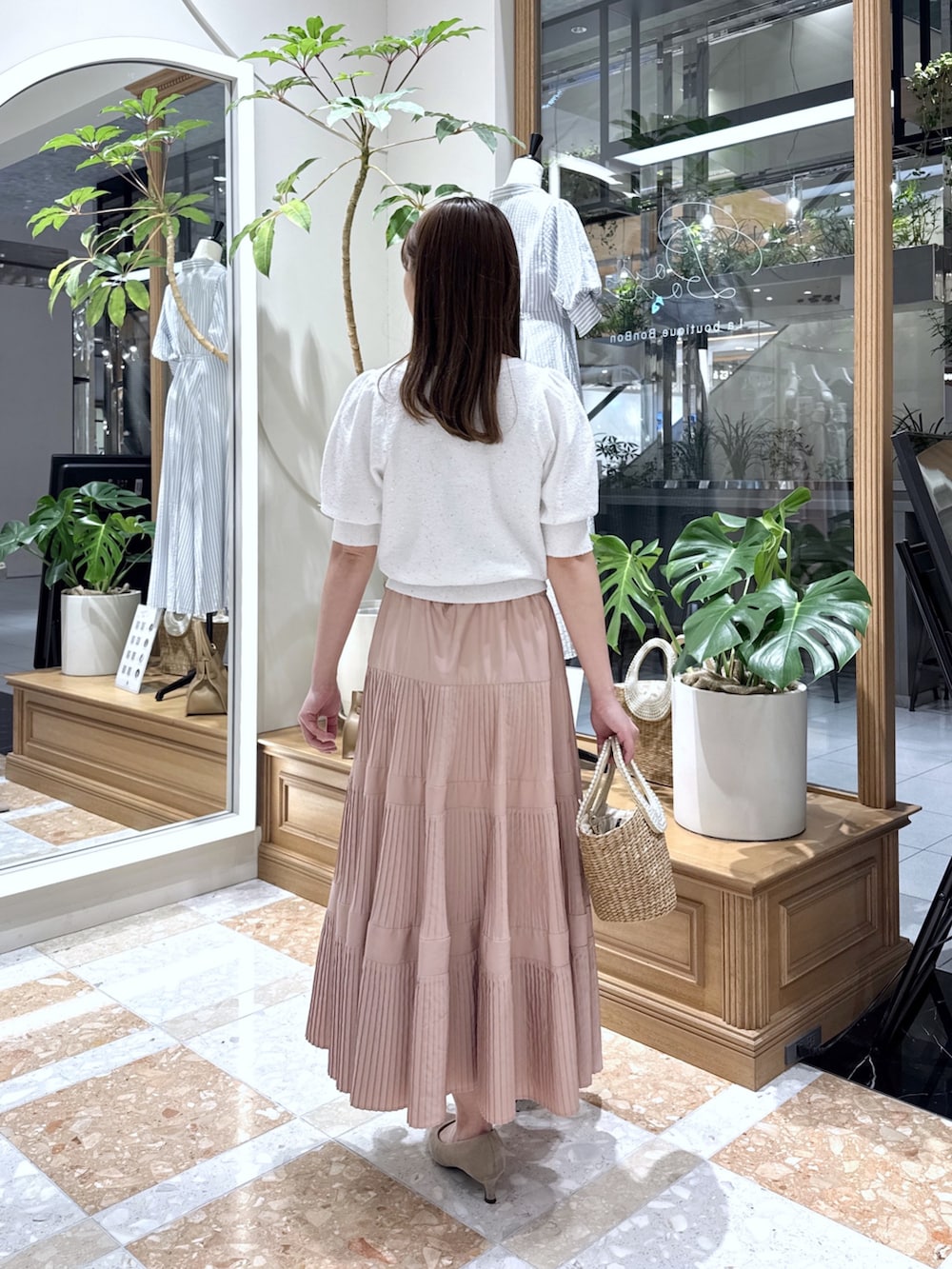 ホワイト系のニット/セーター、ピンク系のスカート、ベージュ系のかごバッグを着用したレディースの春コーディネートの3枚目の写真