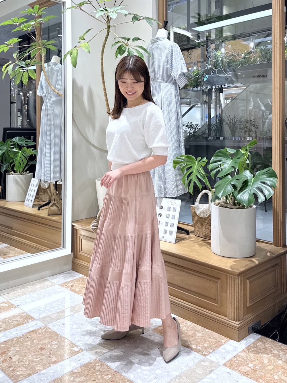 ホワイト系のニット/セーター、ピンク系のスカート、ベージュ系のかごバッグを着用したレディースの春コーディネートの2枚目の写真