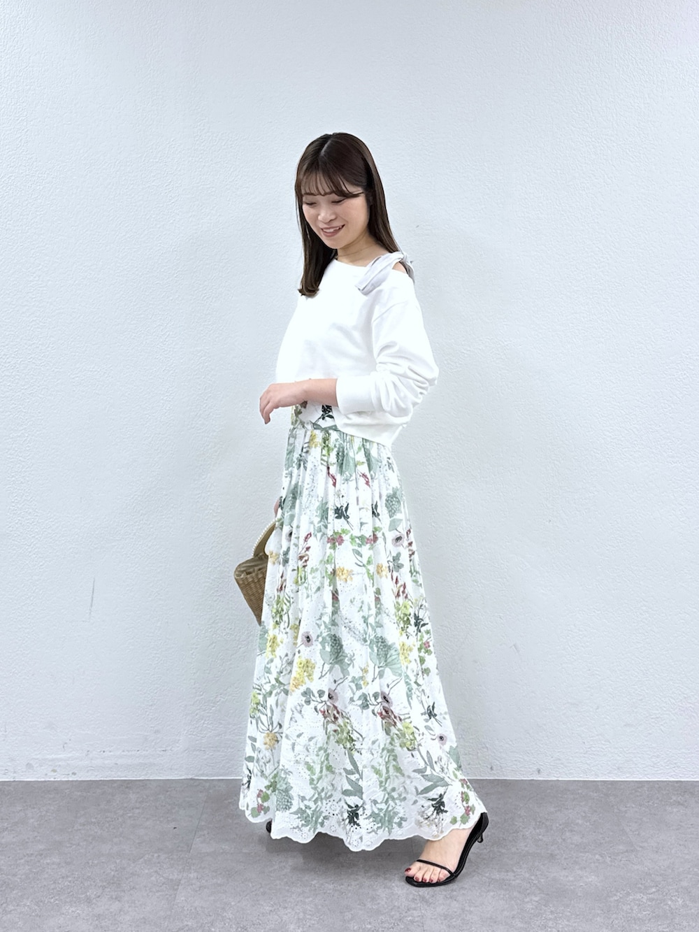 ホワイト系のスウェット、ホワイト系のスカート、ベージュ系のかごバッグを着用したレディースの冬コーディネートの2枚目の写真