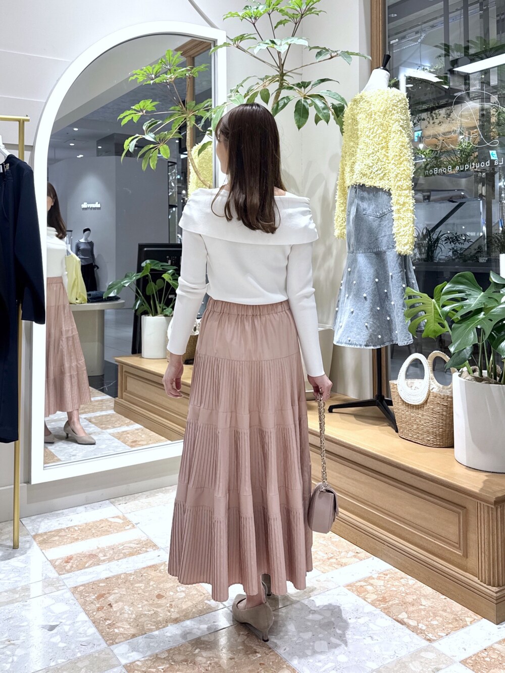 ホワイト系のニット/セーター、ピンク系のスカートを着用したレディースの冬コーディネートの3枚目の写真