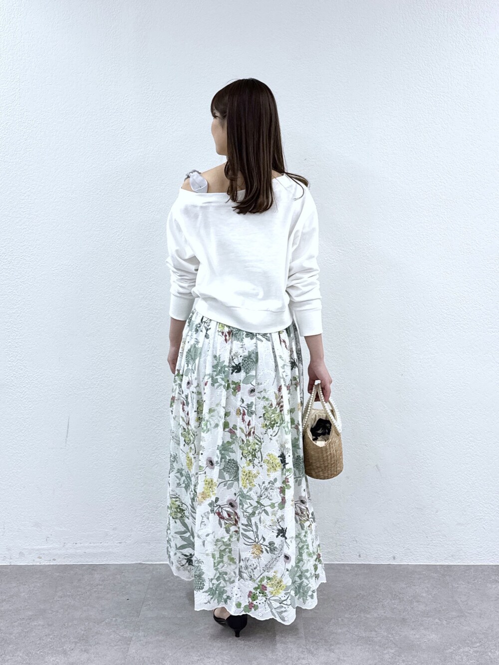 ホワイト系のスウェット、ホワイト系のスカート、ベージュ系のかごバッグを着用したレディースの冬コーディネートの3枚目の写真