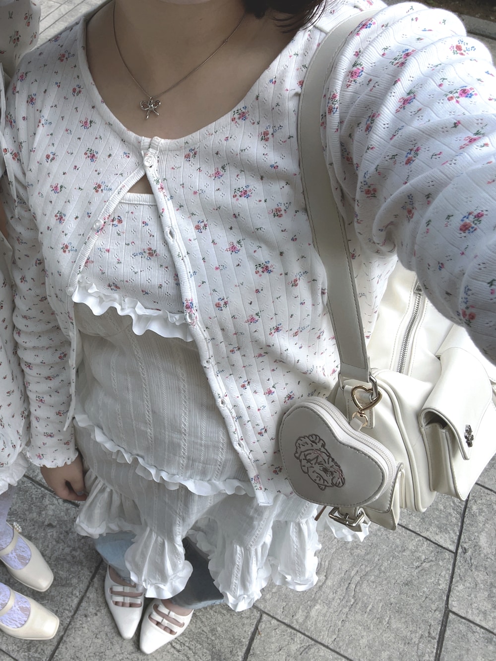 ホワイト系のサンダル、ブルー系のデニムパンツ、ホワイト系のキャミソールを着用したレディースの春コーディネートの2枚目の写真