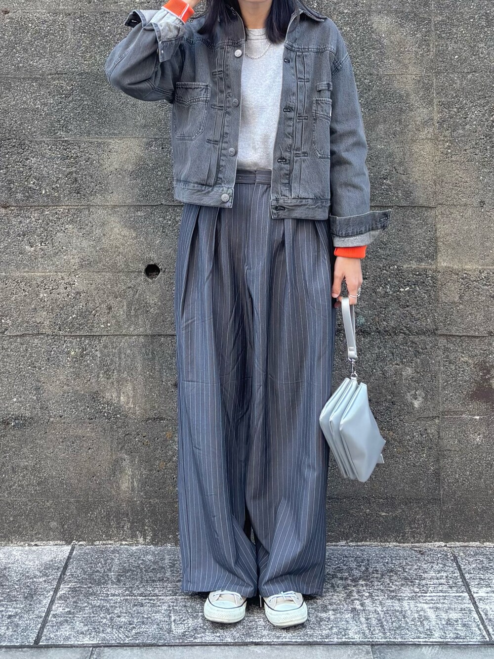 シルバー系のショルダーバッグ、グレー系のニット/セーター、グレー系のスラックスを着用したレディースの冬コーディネートの3枚目の写真