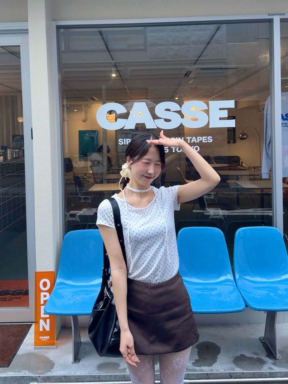 ホワイト系のTシャツ/カットソー、ブラック系のショルダーバッグ、ブラウン系のパンツを着用したレディースの夏コーディネートの2枚目の写真