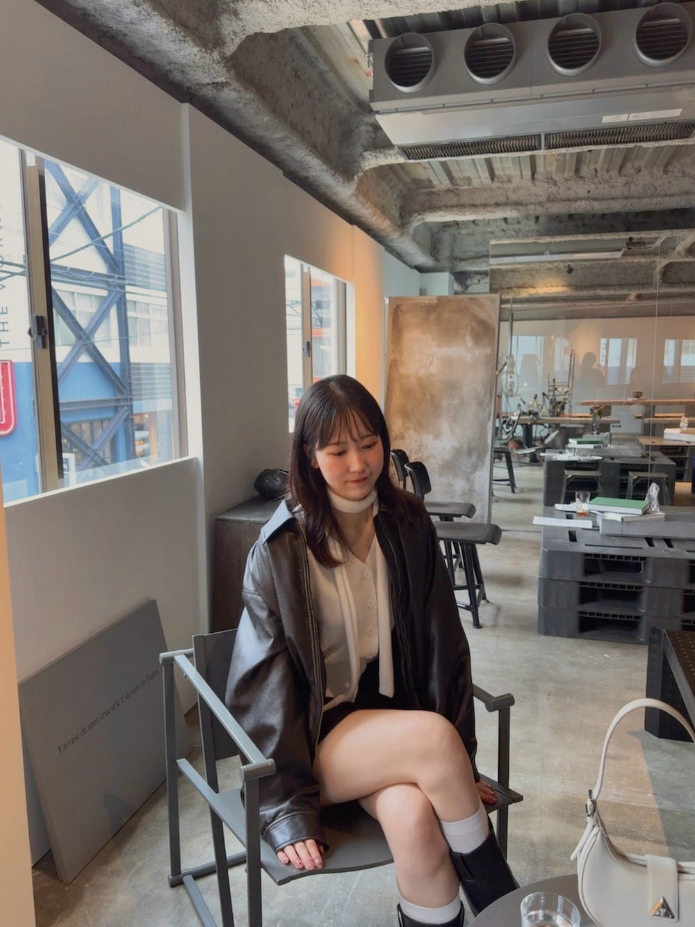 ブラック系のスカート、ブラック系のジャケット/アウター、ホワイト系のカーディガン/ボレロを着用したレディースの秋コーディネートの2枚目の写真