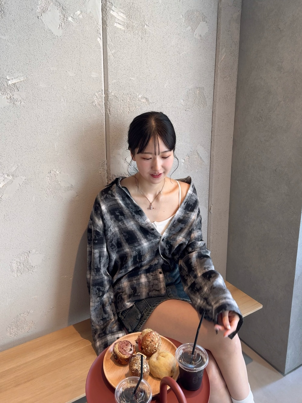 ホワイト系のスニーカー、ブラック系のシャツ/ブラウス、ブルー系のデニムスカートを着用したレディースの秋コーディネートの2枚目の写真