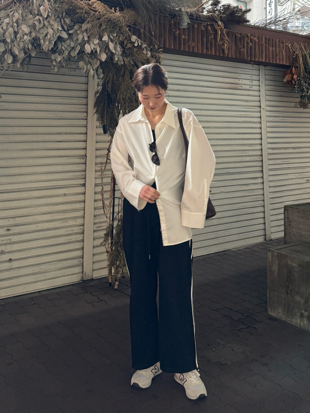 ホワイト系のシャツ/ブラウス、ブラック系のその他パンツ、ホワイト系のスニーカーを着用したレディースの春コーディネートの3枚目の写真