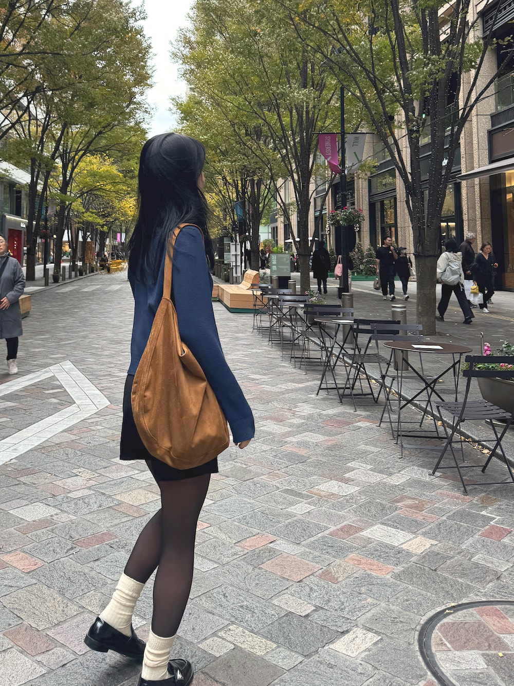 ブルー系のカーディガン/ボレロ、ブラック系のスラックス、ブラック系のローファーを着用したレディースの秋コーディネートの3枚目の写真