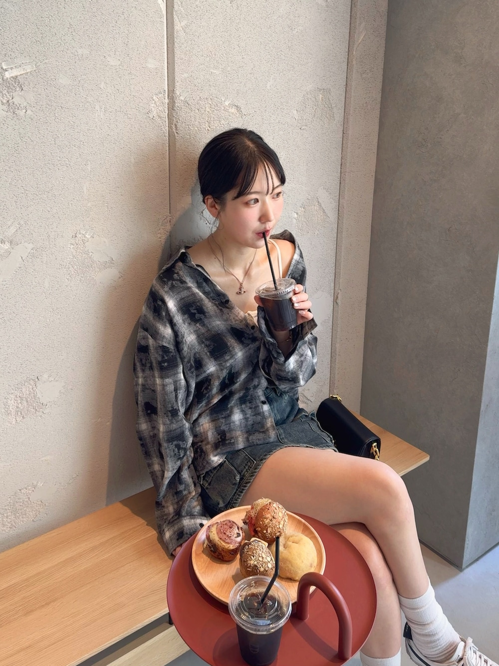 ホワイト系のスニーカー、ブラック系のシャツ/ブラウス、ブルー系のデニムスカートを着用したレディースの秋コーディネートの3枚目の写真