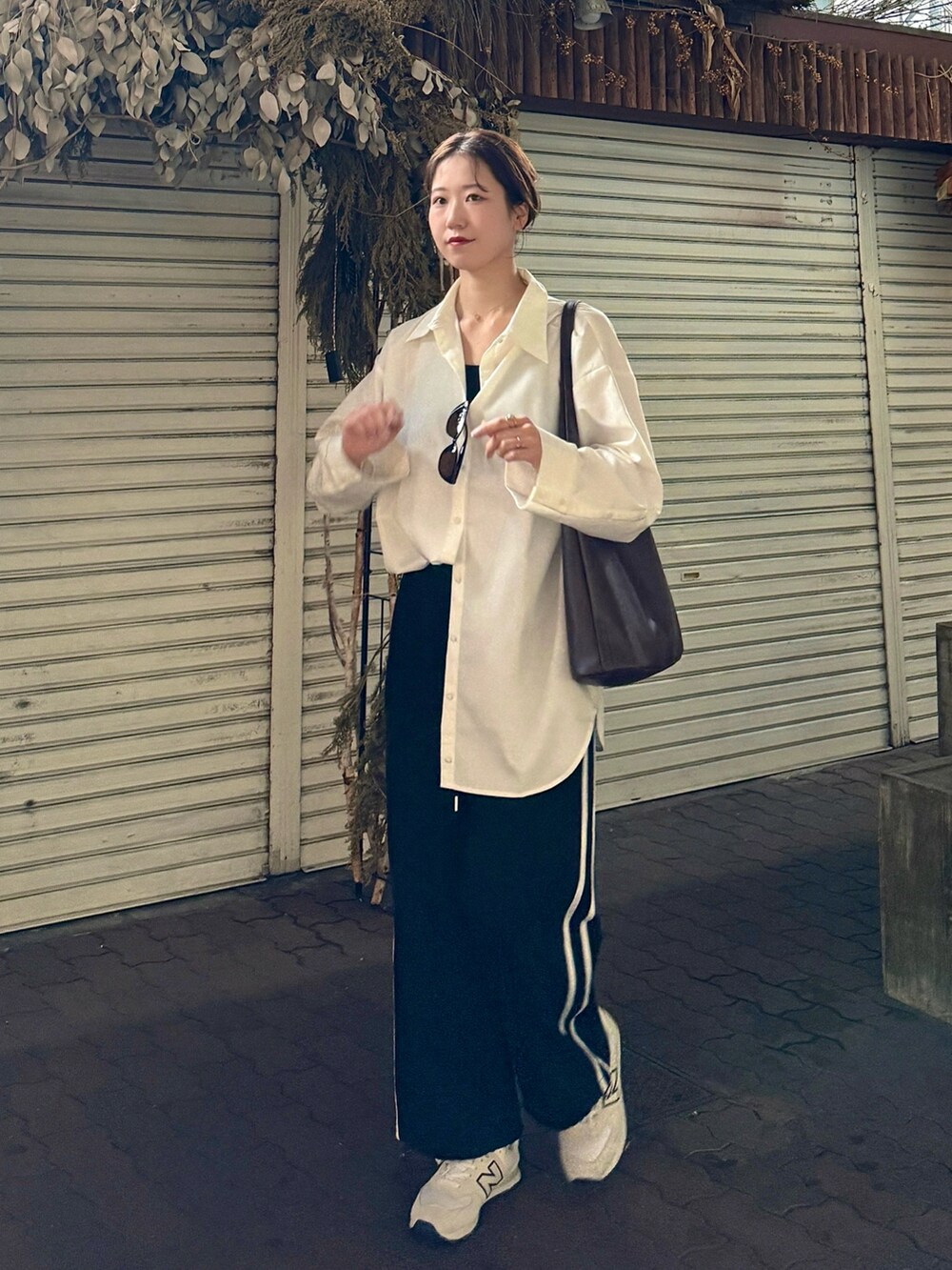 ホワイト系のシャツ/ブラウス、ブラック系のその他パンツ、ホワイト系のスニーカーを着用したレディースの春コーディネートの2枚目の写真