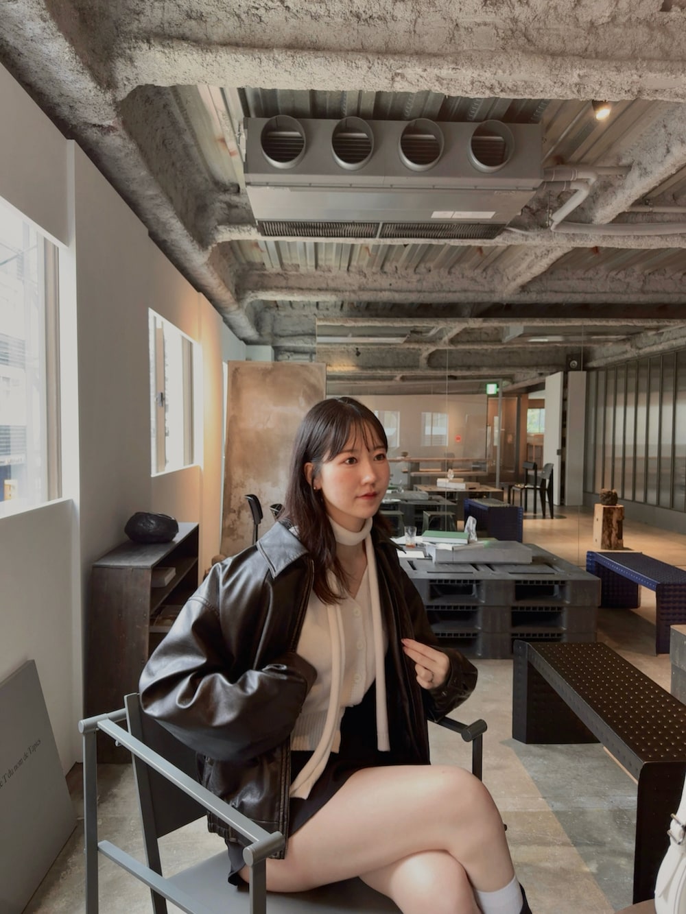 ブラック系のスカート、ブラック系のジャケット/アウター、ホワイト系のカーディガン/ボレロを着用したレディースの秋コーディネートの3枚目の写真